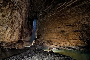 The view back towards the towering entrance and the main river passage in Quankou Dong. Thick beds of limestone break through towards the ceiling high up above the floor of the cave